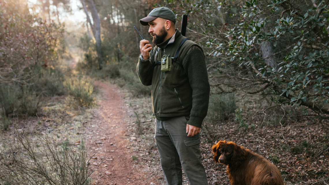 En jeger som bruker jaktradio i skogen