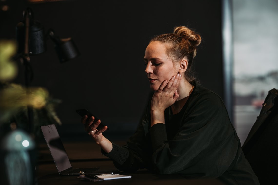 Illustrasjonsbilde som viser kvinne med mobiltelefon i hånden.